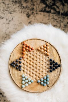 a wooden board with beads arranged in the shape of a bird on top of it