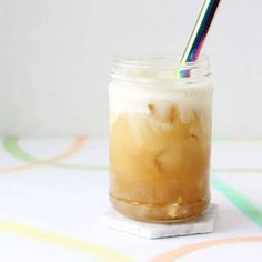 there is a drink in a glass with a rainbow straw sticking out of the top