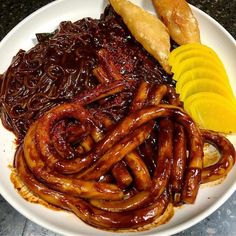 a white plate topped with lots of food on top of a table next to lemon wedges