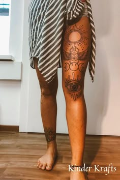 a person with tattoos on their legs standing in front of a window