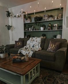 a woman sitting on top of a couch next to a wooden coffee table in front of a book shelf