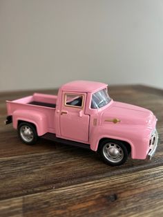 a pink toy truck sitting on top of a wooden table