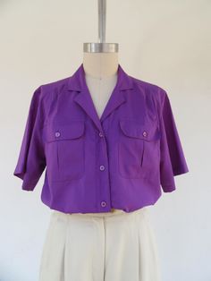 80s or perhaps 90s purple silky button front blouse. Gathered front. Two chest pockets with button closure. It's a real cutie All polyester with a silky look and feel, wash and wear, easy maintenance.  Made in Indonesia for SHERIDAN SQUARE.  Label size 10, fits like M  Please compare measurements to  a similar garment that fits you well Measured flat 17" shoulder to shoulder 20" pit to pit 26" top to bottom  10-1/4" sleeves Good vintage condition with light signs of use and age. Casual Academia, Academia Style, Shirt Business, Business Casual, Womens Clothing Tops, Short Sleeve Shirt, Favorite Outfit, Blouses For Women, Tops & Tees