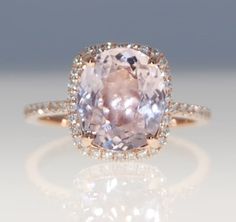 an engagement ring with a large pink diamond in the center and pave diamonds around it