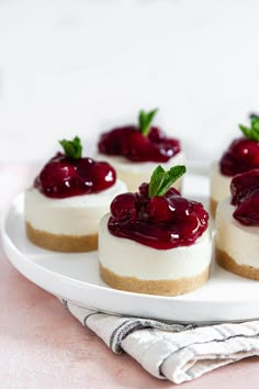 mini cheesecakes topped with cherries on a white plate