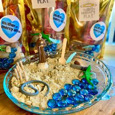 a bowl filled with sand and blue rocks