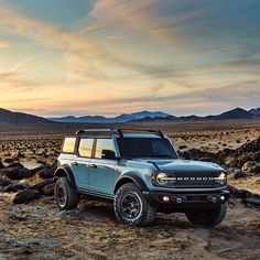 a blue truck parked in the middle of a desert