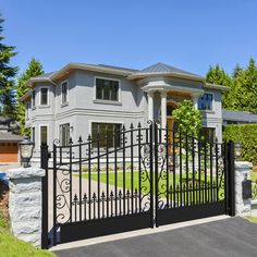 a gated driveway leading to a large house