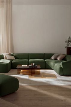 a living room filled with lots of green furniture