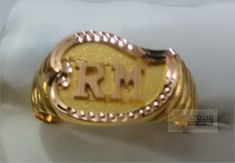 a gold ring with the word rrm engraved on it