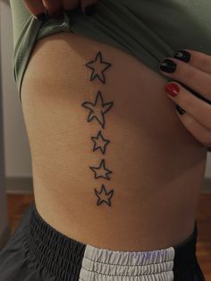 a woman's lower back tattoo with stars on it