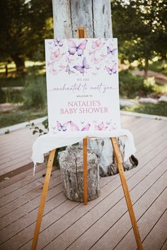 a sign that is sitting on top of a wooden easel in front of a tree