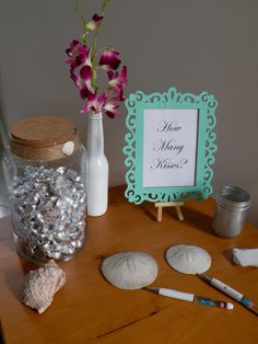 there is a vase with flowers and rocks on the table next to some writing implements