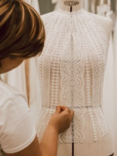 a woman is working on a white dress