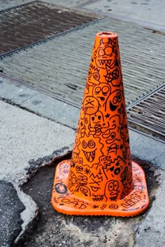 an orange traffic cone sitting on top of a sidewalk