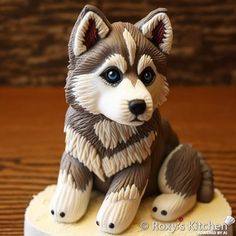 a husky dog figurine sitting on top of a cake