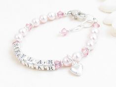 "Pink Beaded Name Bracelet for Child, Infant, Baby, or Little Girl: Created with pink Swarovski pearls and crystals and bright sterling silver spacers. Petite sterling silver alphabet beads spell out her name. The bracelet closes with a high-quality sterling silver heart-shaped lobster clasp with a 1/2\" \"Grow-with-Me\" extender chain. Choose one sterling silver charm. All metal components are sterling silver. Arrives packaged in my signature high-quality reusable canvas gift bag. Beautiful and Pink Beaded Bracelets For Birthday, Pink Beaded Name Bracelet For Birthday, Pink Birthstone Jewelry For Birthday, Pink Birthstone Jewelry For Birthdays, Pearl Jewelry For Birthday And Mother's Day, Pearl Jewelry For Baptism With Round Beads, Hypoallergenic Pearl Jewelry For Birthdays, Hypoallergenic Pink Jewelry For Birthday, Pink Personalized Jewelry For Anniversary