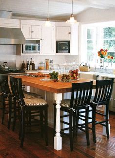 a kitchen island with four chairs around it