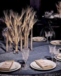 the table is set with wheat stalks and place settings