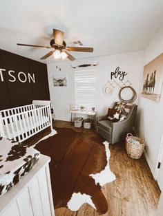 a baby's room with a cow print rug on the floor and a white crib