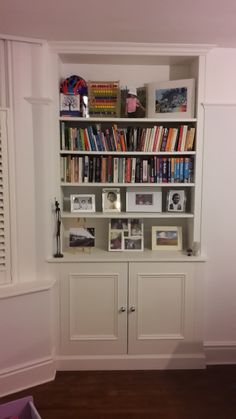 a bookshelf filled with lots of books next to a window