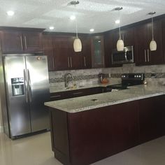 a large kitchen with granite counter tops and stainless steel appliances