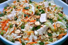 a salad with carrots, lettuce and almonds in a blue bowl