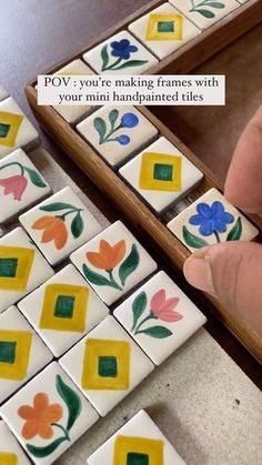 a person is playing with some tiles on the floor and one has their hand painted flowers