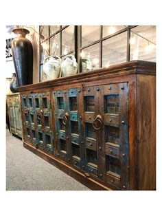 an old wooden cabinet with metal handles and knobs on the doors is displayed in a store