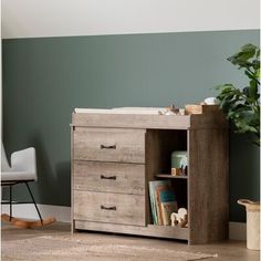 a baby crib with two drawers and a book shelf next to it in a room