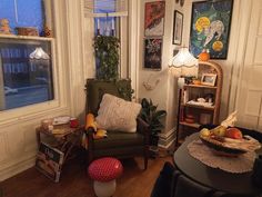 a living room filled with furniture next to a window covered in pictures and fruit on top of a table