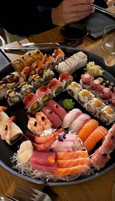 an assortment of sushi on a platter at a restaurant