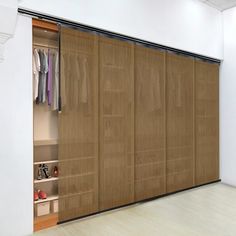 an open closet with clothes hanging on the doors and shoes in the bottom shelfs