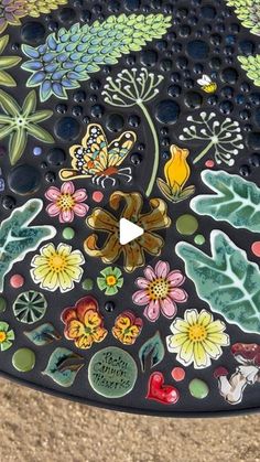 a close up of an artistically designed bench with flowers and butterflies on it's surface