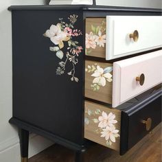 a black dresser with flowers painted on it