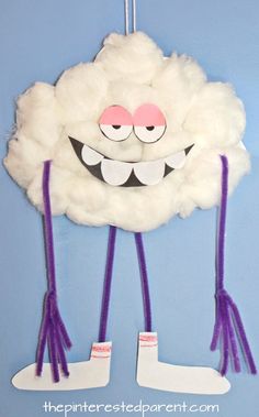 a white cloud with purple legs hanging from it's side on a blue wall