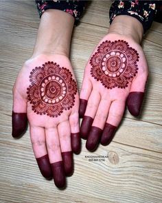 two hands with henna designs on them, one is red and the other is brown