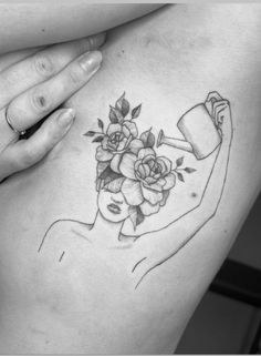 a woman's stomach with flowers and a watering can tattoo on her left side