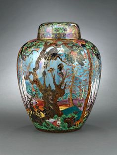 an ornate vase with birds and trees painted on it