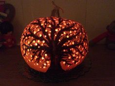 a lighted pumpkin with a tree on it