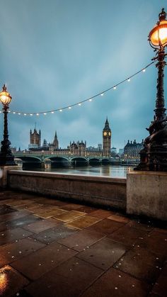 the big ben clock tower towering over the city of london at night with lights on