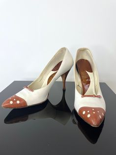 I am a sucker for a spectator, I have to admit, and these are so fab.   From the late 1950s or early 1960s with a painted egg-shell white base and a rusty brown toe cap, bow and heel.  Love the circle cutouts on the toe cap that are also white.  The heel is very narrow, spiked, and the toe box is pointed.  Leather sole.  Based on the insole, the colors are probably original but you can tell that the white is hand painted so it may have been done after market.  Adorable.      Label: Life Stride 8 Retro High Heel Heels For Vintage Fashion, Retro Pointed Toe Heels For Vintage Fashion, Retro High Heels For Vintage Fashion, Retro Pointed Toe Heels For Vintage Occasions, Retro Heels With Pointed Toe For Vintage Fashion, Vintage Closed Toe Heels With 4-inch Heel, Vintage Wedding Heels With 4-inch Heel, Vintage 4-inch Heels For Wedding, Vintage 4-inch Heel Wedding Heels