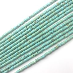 three strands of turquoise green glass beads on a white surface with one bead in the middle