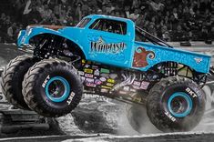 a monster truck with big wheels is in the air