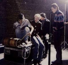 several people are sitting in front of an old barrel and some microphones on a stage