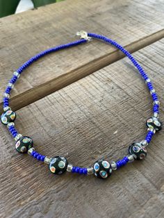 Royal blue choker with seed beads and glass accent beads Blue Tiny Beads Choker For Festival, Blue Beaded Choker For Festival, Blue Spacer Beads For Festivals, Blue Adjustable Choker For Festival, Adjustable Blue Choker For Festivals, Blue And Black Beads Bohemian Necklace, Bohemian Blue And Black Beaded Necklaces, Blue Silver Beaded Festival Necklace, Blue Glass Beaded Bohemian Necklace