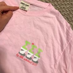 a person holding onto a pink shirt with two cups on it