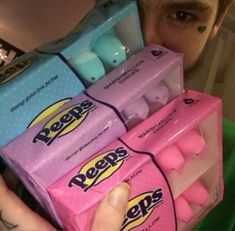 a man holding three boxes of peeps candy