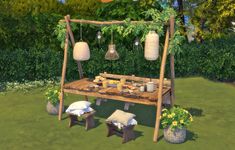 a picnic table in the middle of a garden with hanging lanterns and potted plants