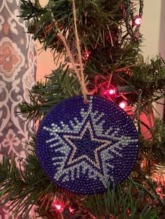 a blue ornament hanging from a christmas tree